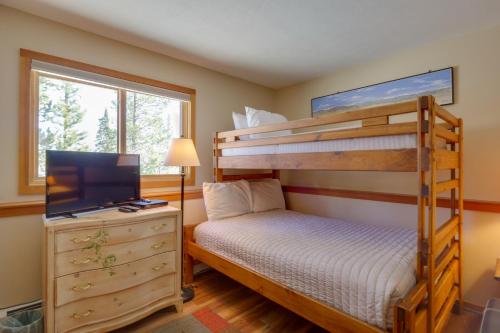 a bedroom with a bunk bed and a flat screen tv at Silverthorne Condo Patio, Mtn Views, Pool Access! in Silverthorne