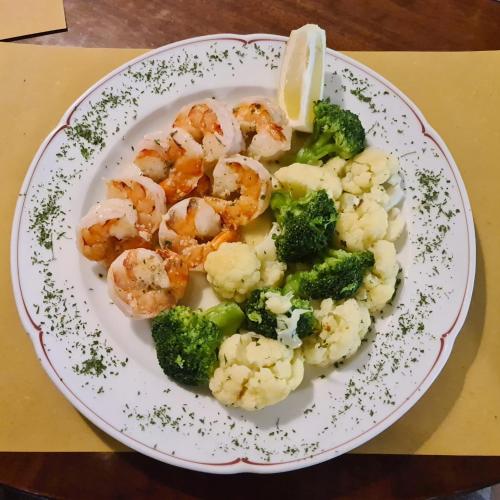 a plate of shrimp and broccoli on a table at Ristorante della Stazione in Tegna