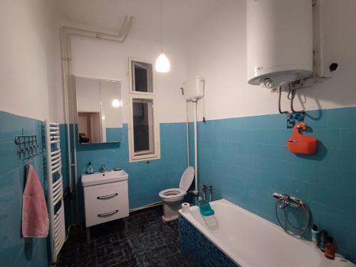 a blue and white bathroom with a toilet and a tub at Vintage apartment in the center of Novi Sad in Novi Sad