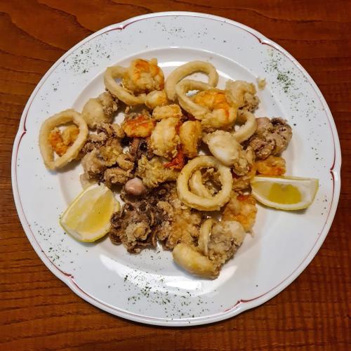 a plate of food with shrimp and lemon slices at Ristorante della Stazione in Tegna