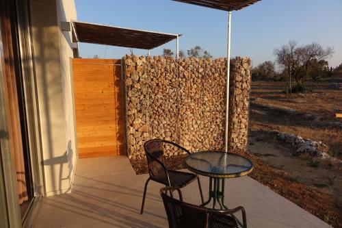 a patio with a table and chairs and a fence at giardino del tempo in Merine