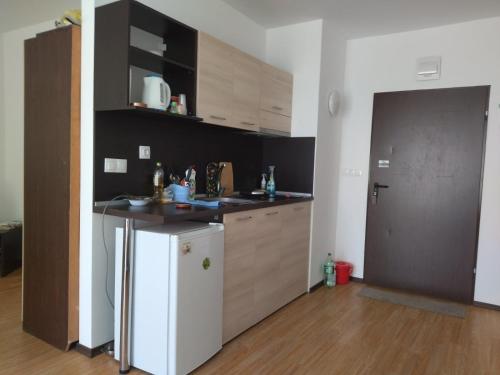 a kitchen with a white refrigerator and a counter at Апартамент Тита in Burgas