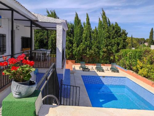 - une piscine avec un vase de fleurs rouges à côté d'une maison dans l'établissement Lille en Provence, à Valence