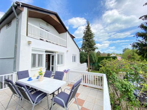 a patio with a table and chairs on a balcony at Dandelion Szépvölgyi Vendégház in Badacsonytomaj