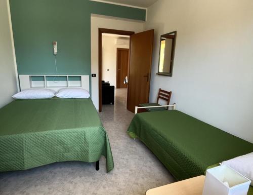a bedroom with two green beds and a chair at Case Vacanza Calabria Ionica in Cropani