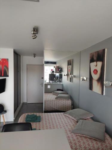 a room with two beds and a mirror at Studio Heliopolis Naturiste in Cap d'Agde