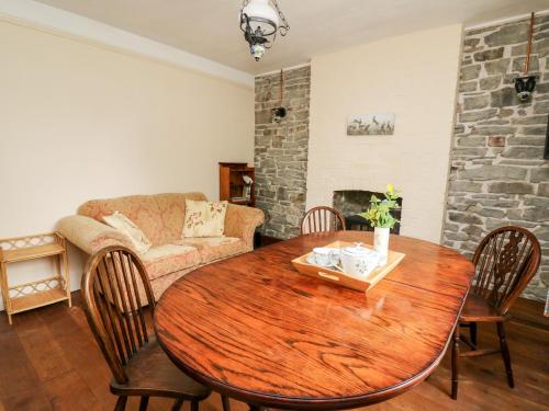 a living room with a wooden table and a couch at Myrtle Villa in Knighton