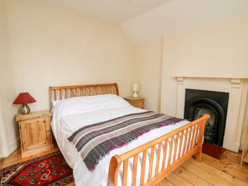een slaapkamer met een bed en een open haard bij Myrtle Villa in Knighton