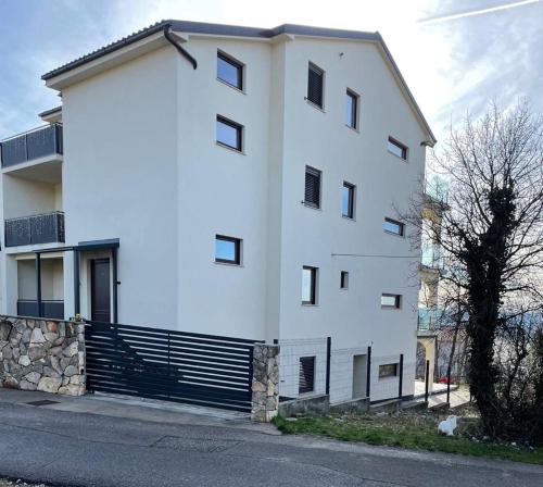 a white building on the side of a street at APPARTMENTS SARA in Jadranovo