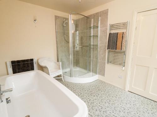 a bathroom with a bath tub and a shower at Myrtle Villa in Knighton
