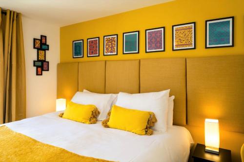 a bedroom with a bed with two yellow pillows at Pier Reflections - seafront apartment in Eastbourne