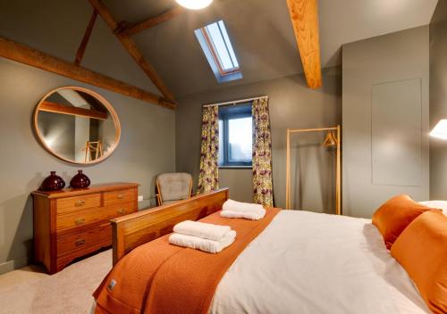 a bedroom with a bed with two towels on it at The Foldyard in Holme upon Spalding Moor