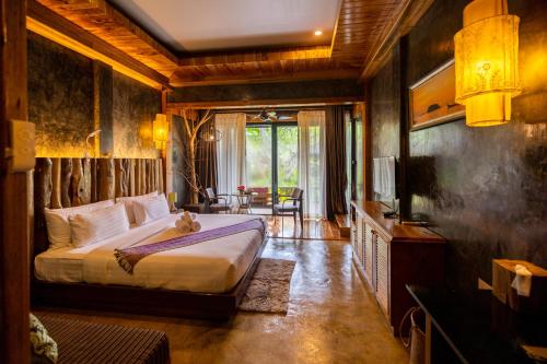 a bedroom with a bed and a television in it at Andalay Beach Resort Koh Libong in Ko Libong