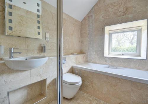 a bathroom with a toilet and a sink and a bath tub at The Cottage in Whitby