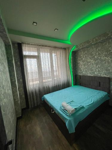 a room with a bed with green lights on it at Avchieva's apartment on Orbeli Brothers Street in Yerevan