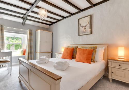 een slaapkamer met een groot bed en handdoeken bij The Cottage in Thwaite