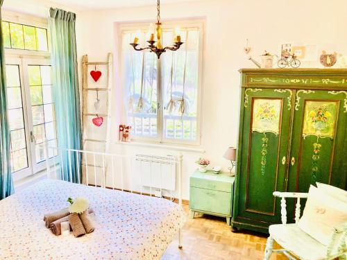 a bedroom with a bed and a green cabinet at Casa Angiolina - Holidays in Morcote