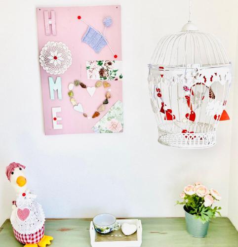 a room with a bird cage and flowers on a table at Casa Angiolina - Holidays in Morcote
