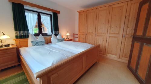 a bedroom with a large wooden bed with a window at Grafn-Hof in Schleching