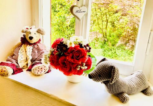 two teddy bears sitting on a window sill with flowers at Casa Angiolina - Holidays in Morcote