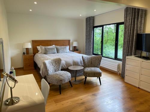 een slaapkamer met een bed en een tafel en stoelen bij White Lodge B&B in Cooksbridge