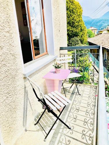 a pink table and chairs on a balcony at Casa Angiolina - Holidays in Morcote