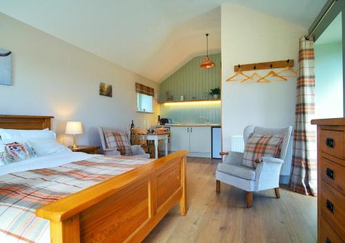 a bedroom with a large bed and a kitchen at The Bothy in Carlton
