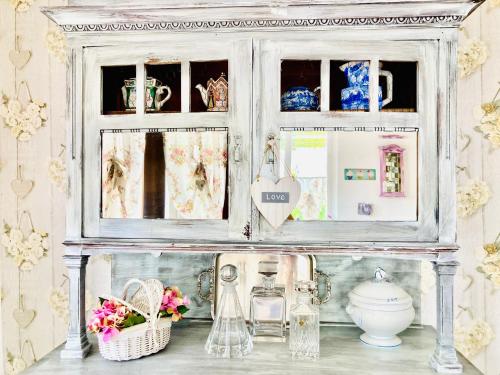 a shelf in a kitchen with flowers and dishes at Casa Angiolina - Holidays in Morcote