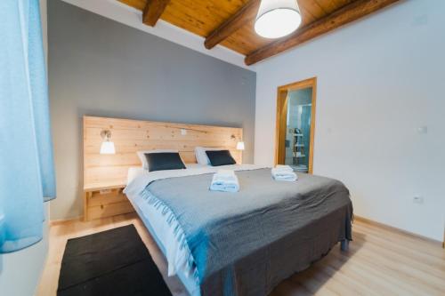 a bedroom with a large bed with a wooden headboard at Casa Verde and Casa Blue in Janja Gora