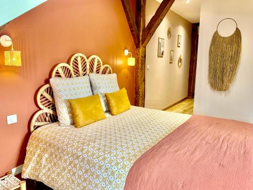 sypialnia z dużym łóżkiem z żółtymi i niebieskimi poduszkami w obiekcie Les Chambres de La Varenne w mieście La Flèche