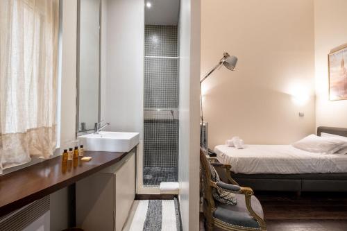 une salle de bain avec un lavabo et une chambre avec un lit dans l'établissement Veeve - Heart of Saint Germain, à Paris