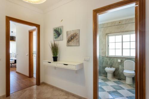 a bathroom with a toilet and a window at Privilege Apartment Magnolia, Olhão in Olhão