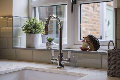 a kitchen sink with a faucet next to a window at The Hoglets 2 in Goostrey