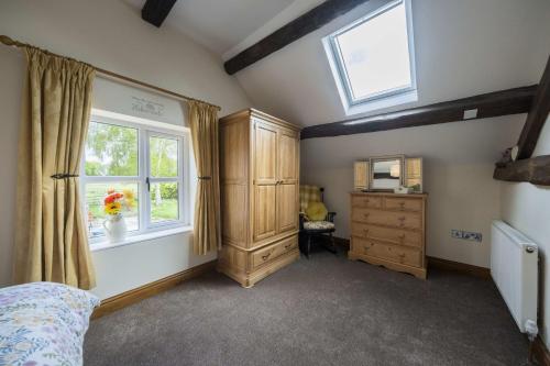 a bedroom with a bed and a window and a dresser at The Hoglets 2 in Goostrey