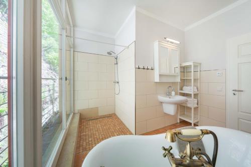 y baño con bañera y lavamanos. en Villa Emma, Wellness & Ayurveda, en Bad Schandau