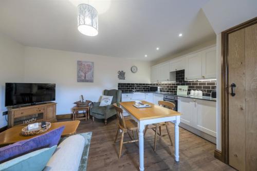 a living room with a table and a kitchen at The Hoglets 3 in Goostrey