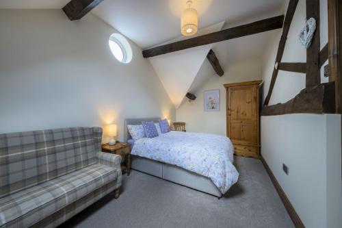 1 dormitorio con 1 cama y 1 sofá en The Hoglets 3, en Goostrey