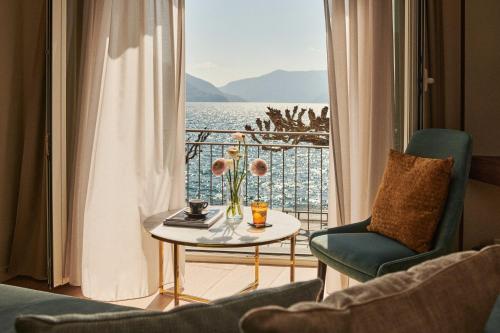 Zimmer mit einem Tisch und Stühlen sowie Blick auf das Wasser in der Unterkunft Vista Lakefront Boutique Hotel in Ascona
