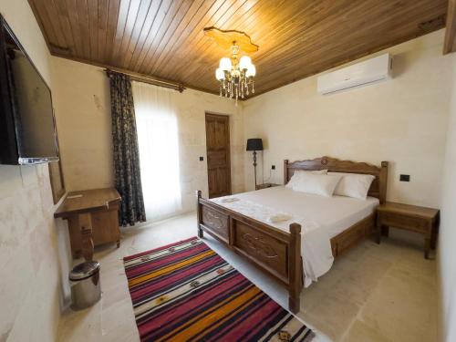 a bedroom with a bed and a chandelier at PALMYRA BOUTIQUE HOTEL in Urfa