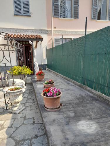 three potted plants on a sidewalk in front of a fence at Da Betty in Asti