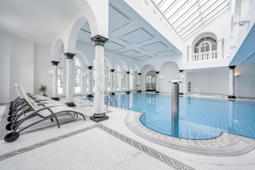 uma piscina num edifício com cadeiras e uma piscina em Relais & Châteaux Chasa Montana em Samnaun