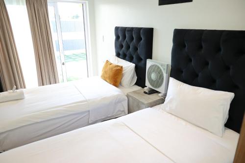 a hotel room with two beds and a tv at El-Gibor Best Guest House in Cape Town