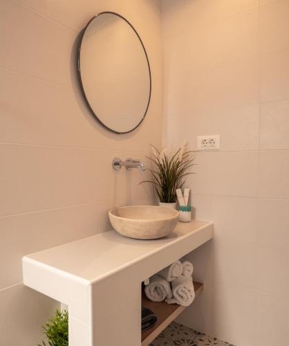 a bathroom with a bowl sink and a mirror at Ammos Sifnos Village in Platis Yialos Sifnos