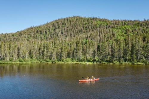 a group of people in a red boat on a river at Auberge de Montagne des Chic-Chocs Mountain Lodge - Sepaq in Sainte-Anne-des-Monts