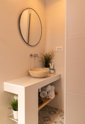 a bathroom with a bowl sink and a mirror at Ammos Sifnos Village in Platis Yialos Sifnos