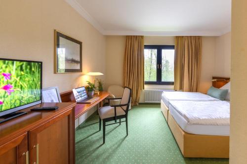a hotel room with a bed and a desk at Dreams Beckum in Beckum