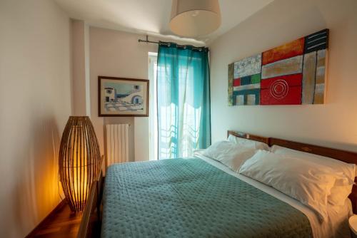 une chambre avec un lit avec une couverture bleue et une fenêtre dans l'établissement Eco di Mare - Apartment, à Polignano a Mare