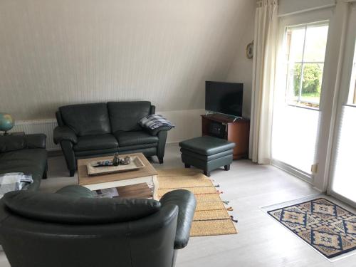 a living room with couches and a coffee table at Wohnen im Alten Land in Grünendeich