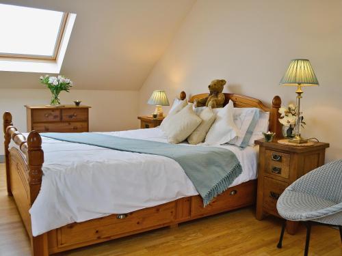 a bedroom with a bed with a teddy bear on it at Field View in Cynghordy