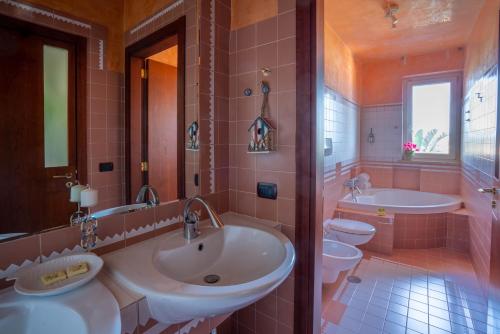 - une salle de bains rose avec 2 lavabos et 2 toilettes dans l'établissement Eco di Mare - Apartment, à Polignano a Mare